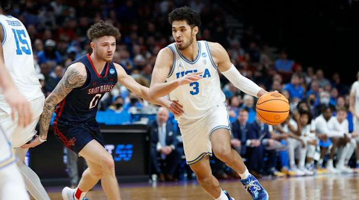UCLA guard Johnny Juzang (3) drives around St. Mary’s guard Logan Johnson (0) during the first half of a second-round NCAA college basketball tournament game, Saturday, March 19, 2022, in Portland, Ore.
